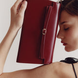 Woman holding a Dark Cherry Shoulder Purse Handbag against a plain background