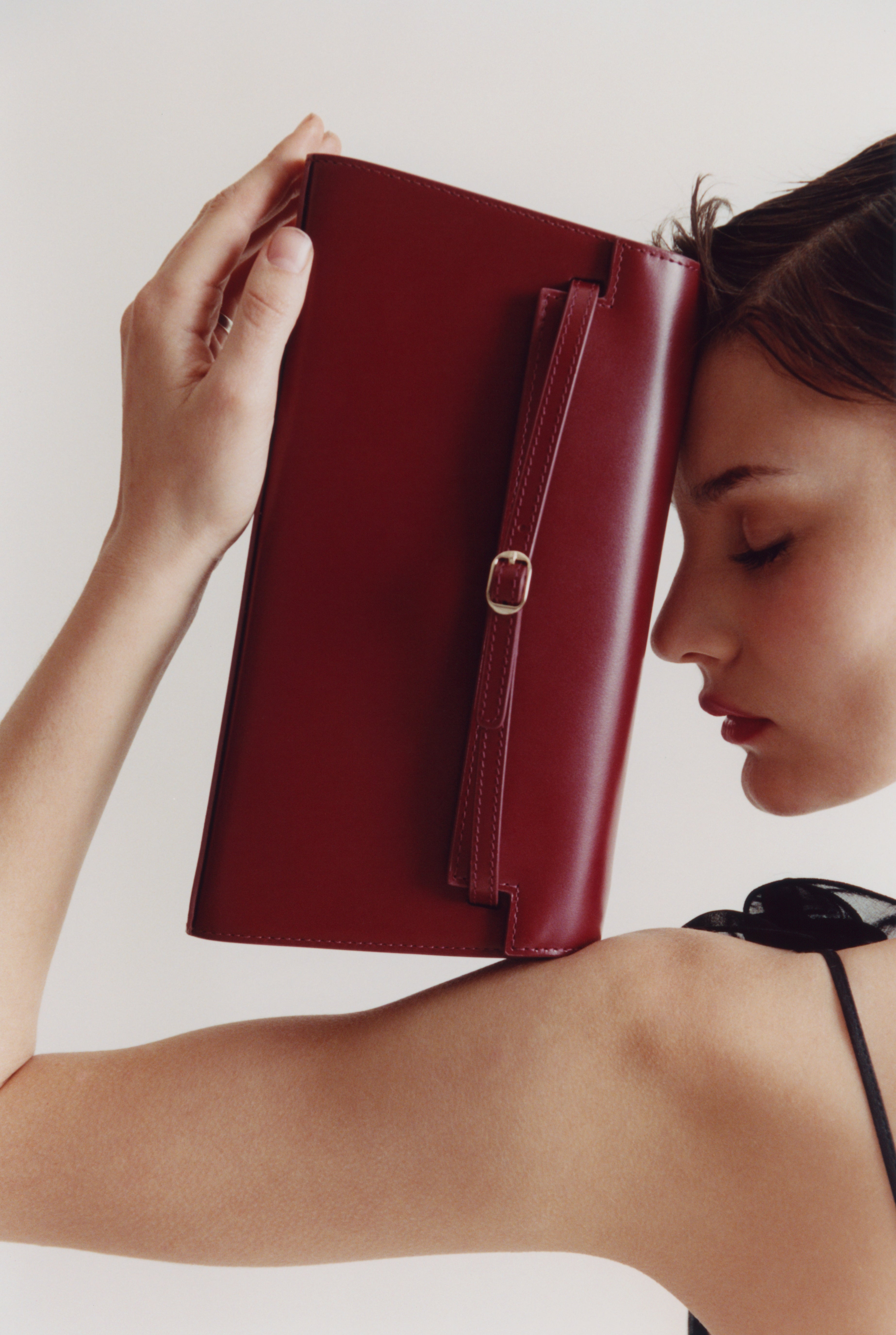 Woman holding a Dark Cherry Shoulder Purse Handbag against a plain background