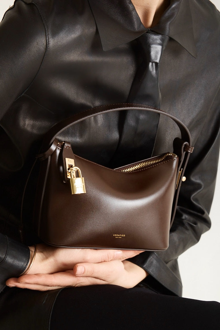 A person holding a Mini Gold Chocolate Hobo Shoulder Handbag