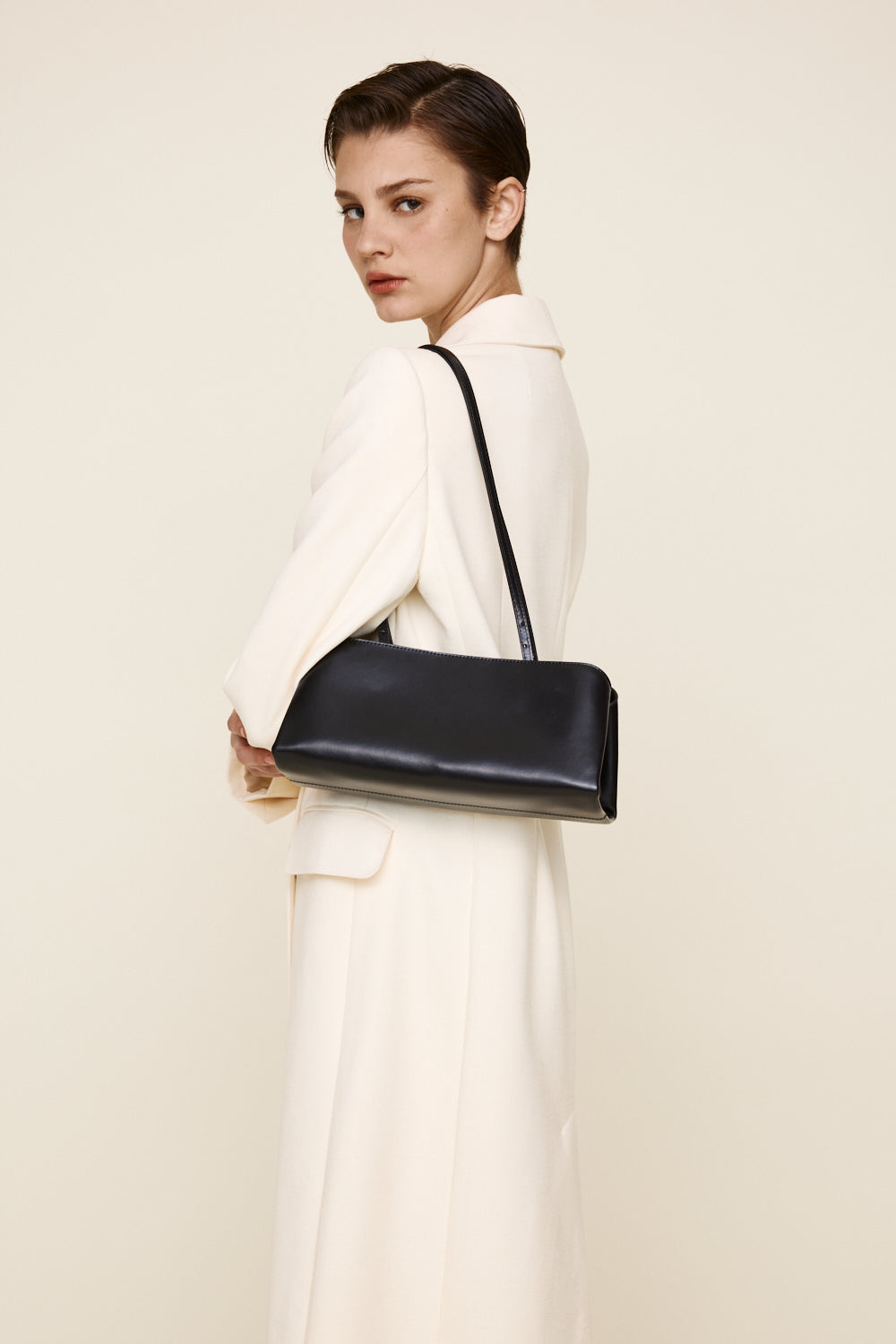 Woman holding a Silver Noir Éclair Clutch Shoulder Handbag (Black) against a plain background