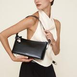 Woman holding a Silver Black Hobo Shoulder Handbag against a plain background