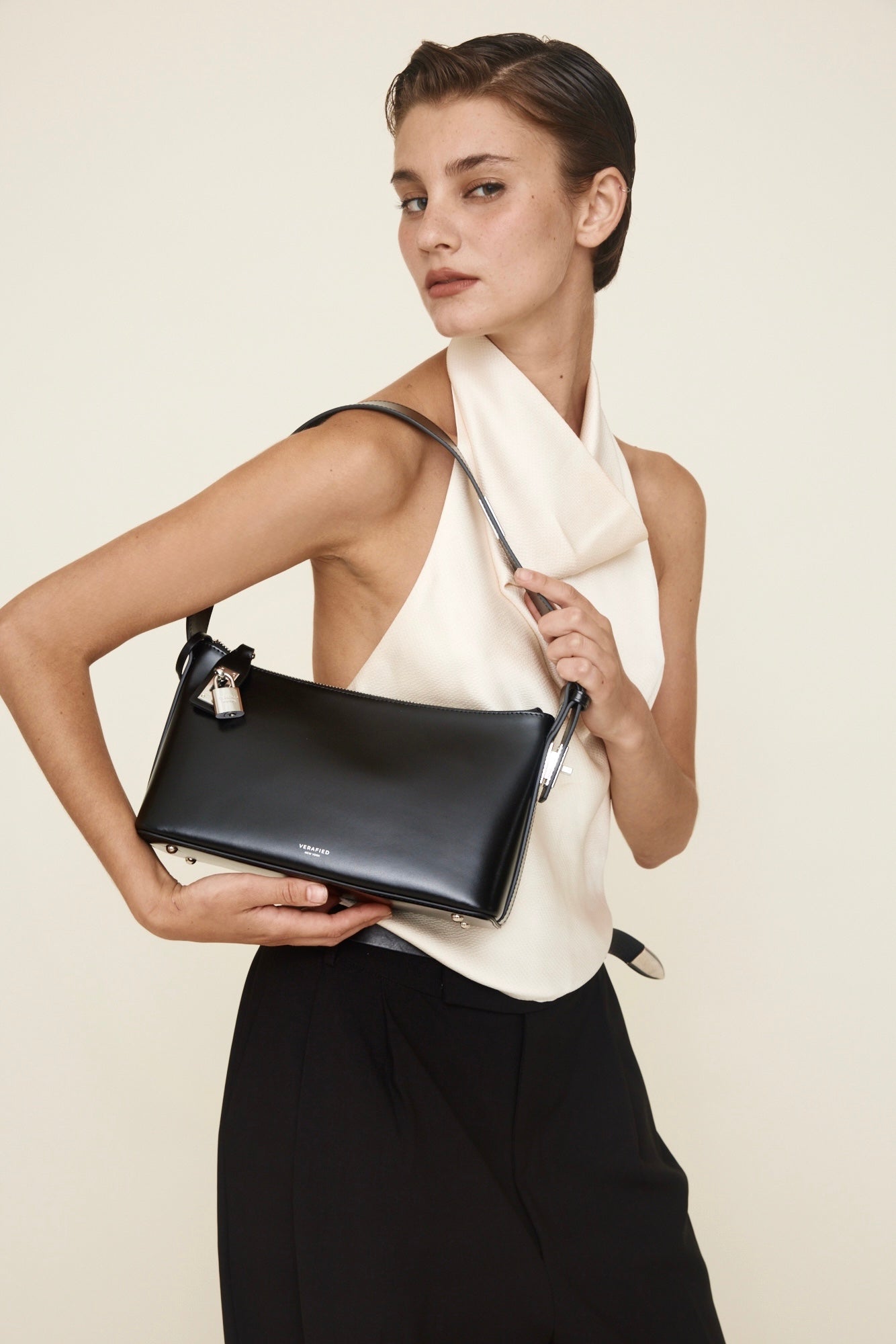 Woman holding a Silver Black Hobo Shoulder Handbag against a plain background