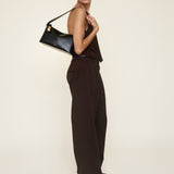 Woman holding a Gold Black Hobo Shoulder Handbag against a plain background
