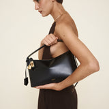 Woman holding a Gold Black Hobo Shoulder Handbag against a neutral background
