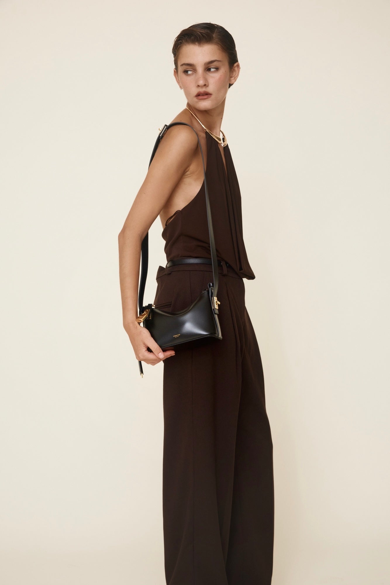 Woman holding a Mini Gold Black Hobo Shoulder Handbag against a plain background
