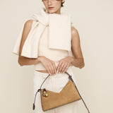Woman holding a beige Gold Suede Hobo Shoulder Handbag against a plain background