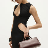 Woman in a black dress holding a Burgundy Clutch Shoulder Handbag against a white background