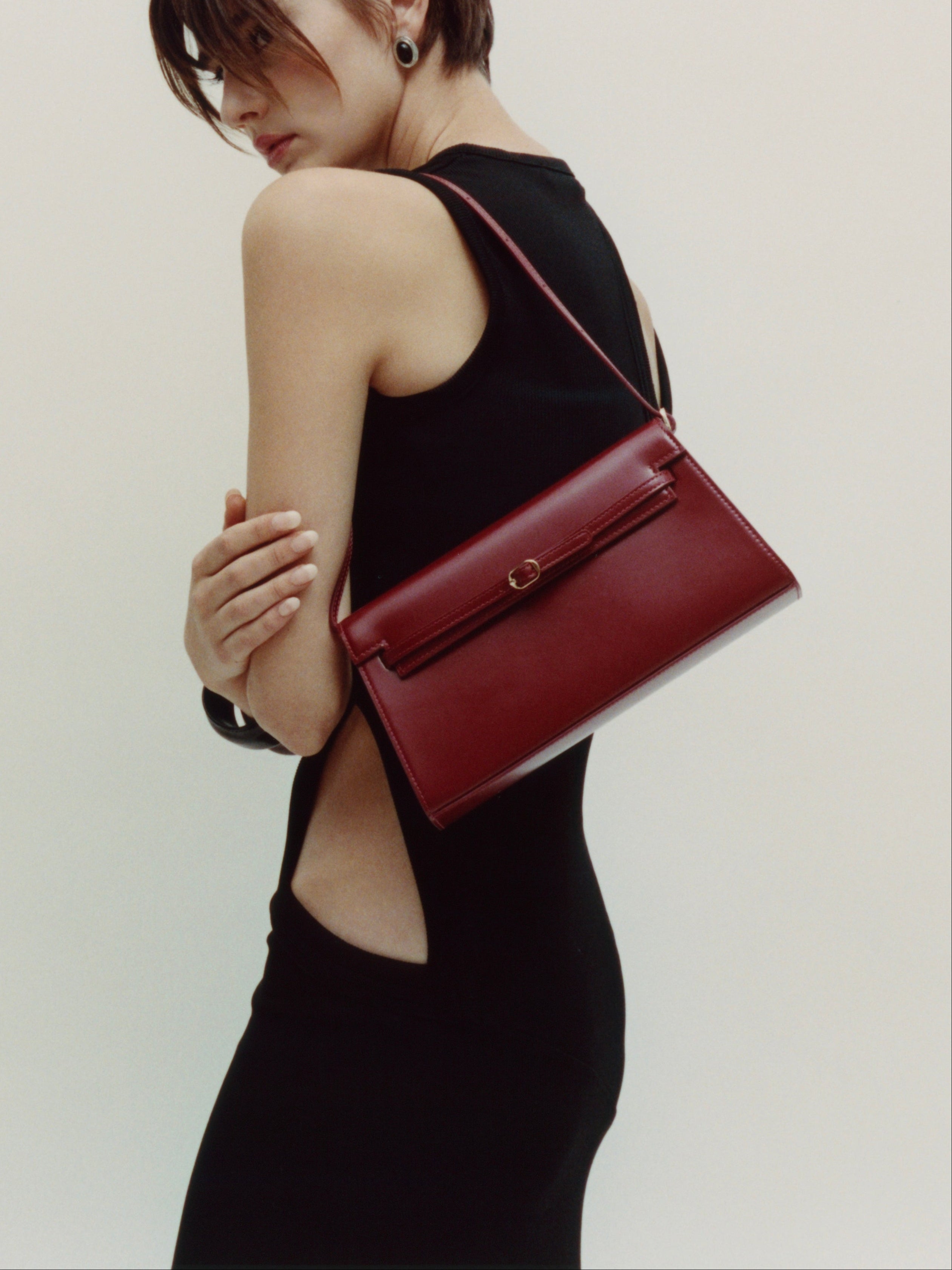 Woman holding a Dark Cherry Shoulder Purse Handbag against a plain background