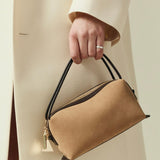 Verafied New York Gold Suede Café Mini Handbag held by a person wearing a beige coat against a neutral background