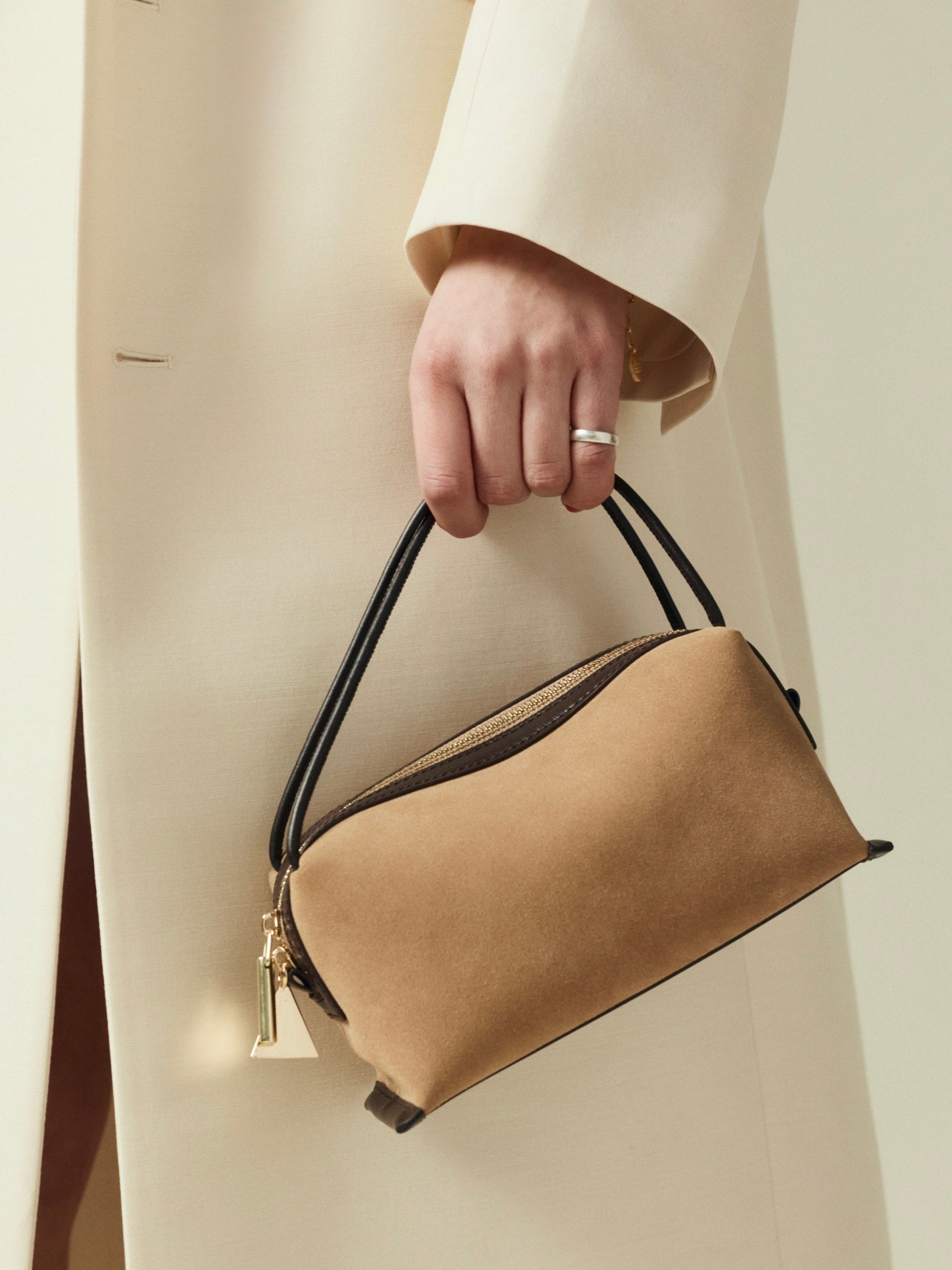 Verafied New York Gold Suede Café Mini Handbag held by a person wearing a beige coat against a neutral background