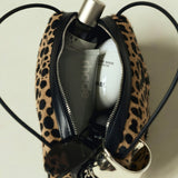 Leopard print Verafied New York Cheetah Calf Hair Café Mini Handbag with grooming products on a light background
