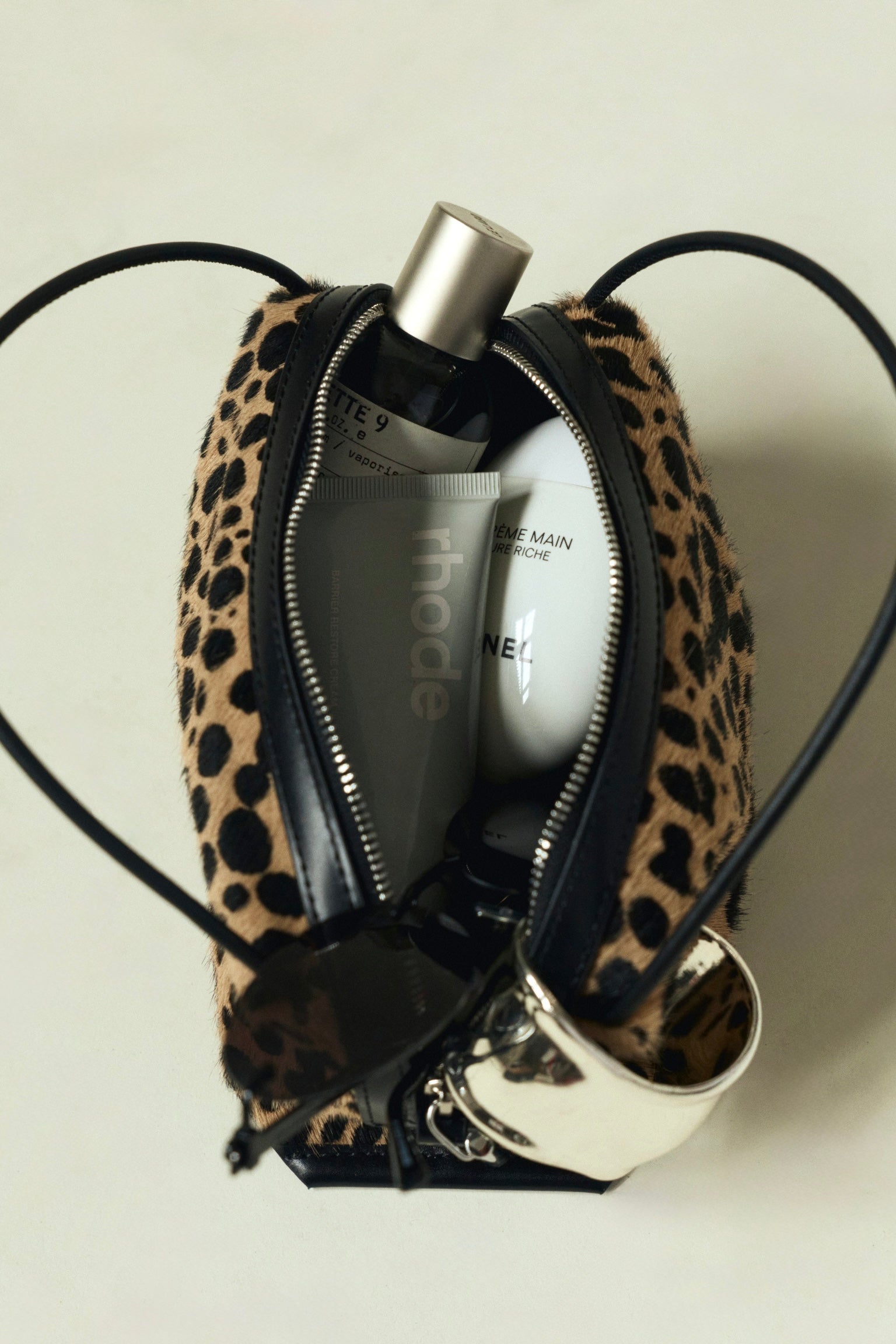 Leopard print Verafied New York Cheetah Calf Hair Café Mini Handbag with grooming products on a light background