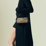 Person wearing a black outfit with a leopard print Verafied New York Cheetah Calf Hair Café Mini Handbag on a beige background