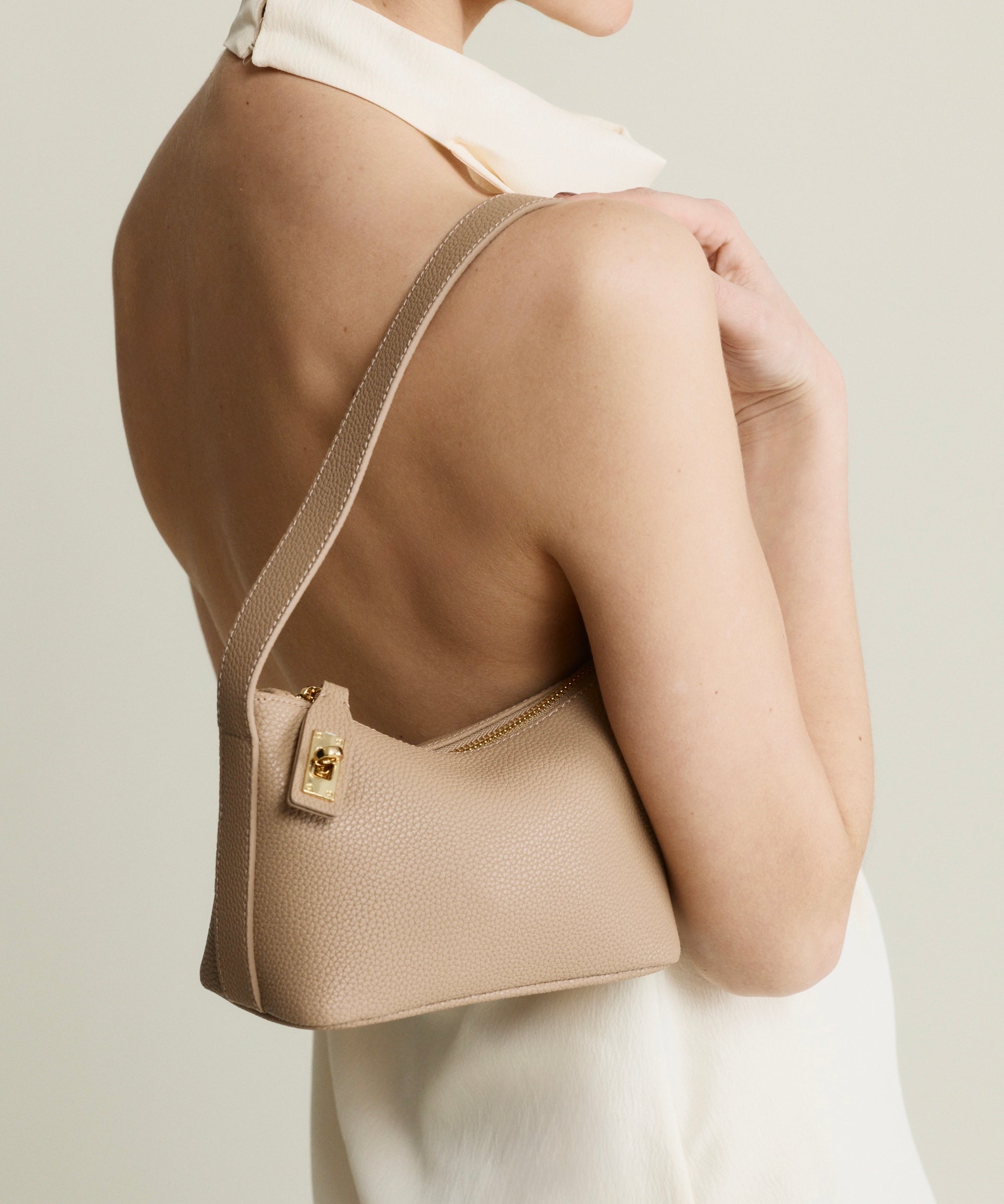Beige Twister Hobo Shoulder Handbag worn over shoulder on a plain background