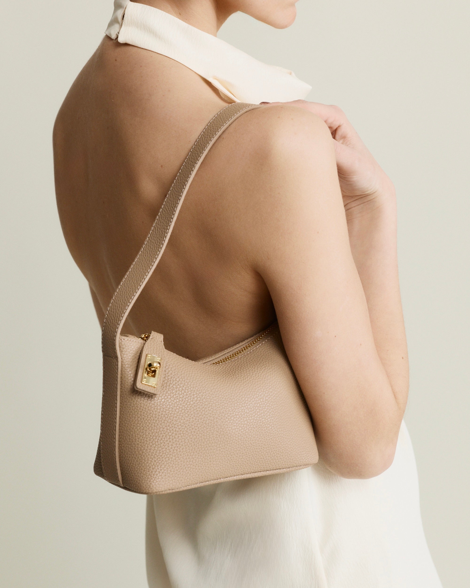 Beige Twister Hobo Shoulder Handbag worn over shoulder on a plain background
