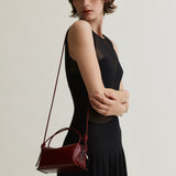 Woman holding a Maroon Python Café Mini Bag: Crossbody Handbag against a plain background