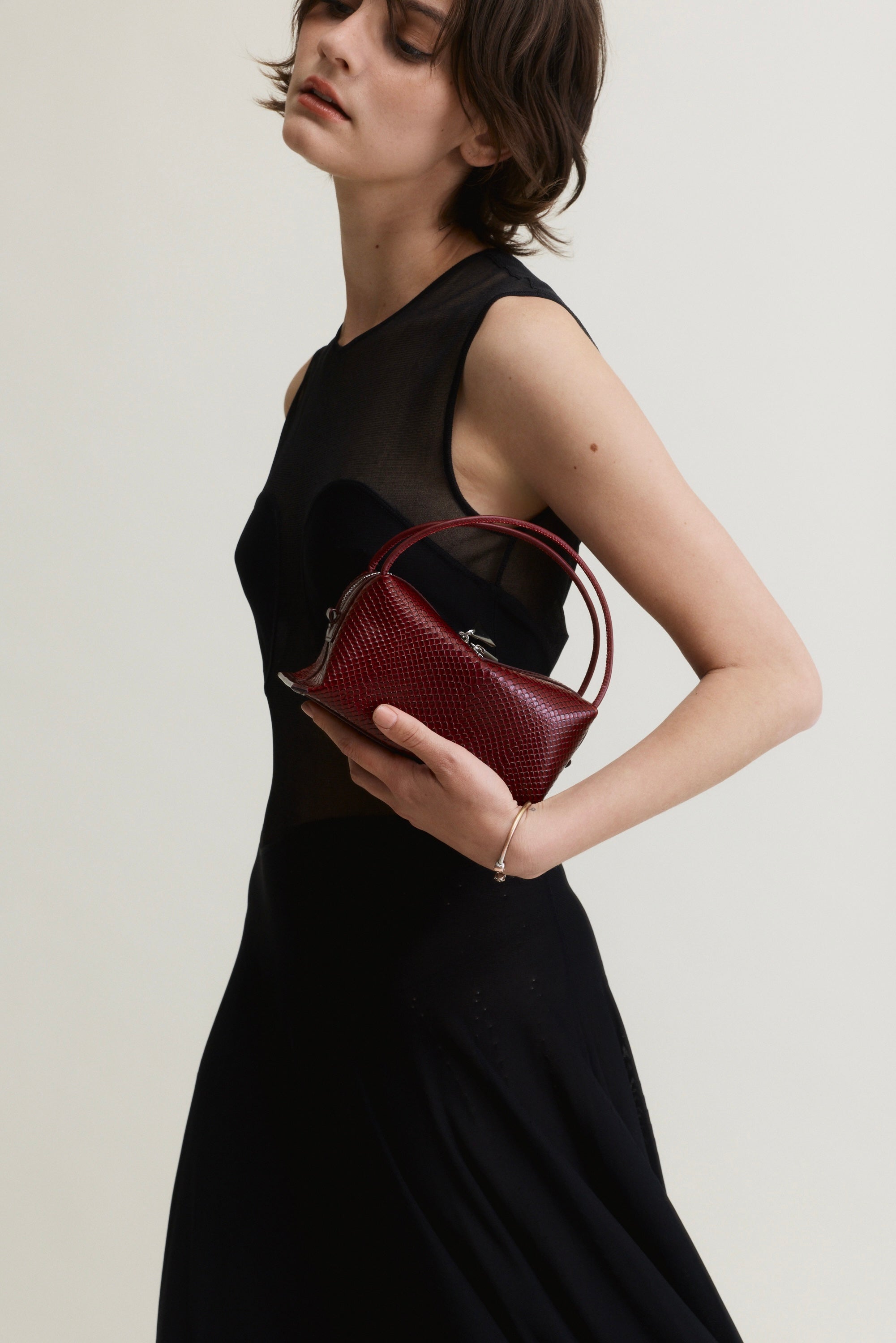 Woman holding a Maroon Python Café Mini Bag: Crossbody Handbag against a plain background