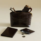 Mocha Croc Makeup Pouch with accessories on a beige background