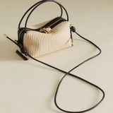 Raffia Café Mini Crossbody Handbag with a long black strap on a light background