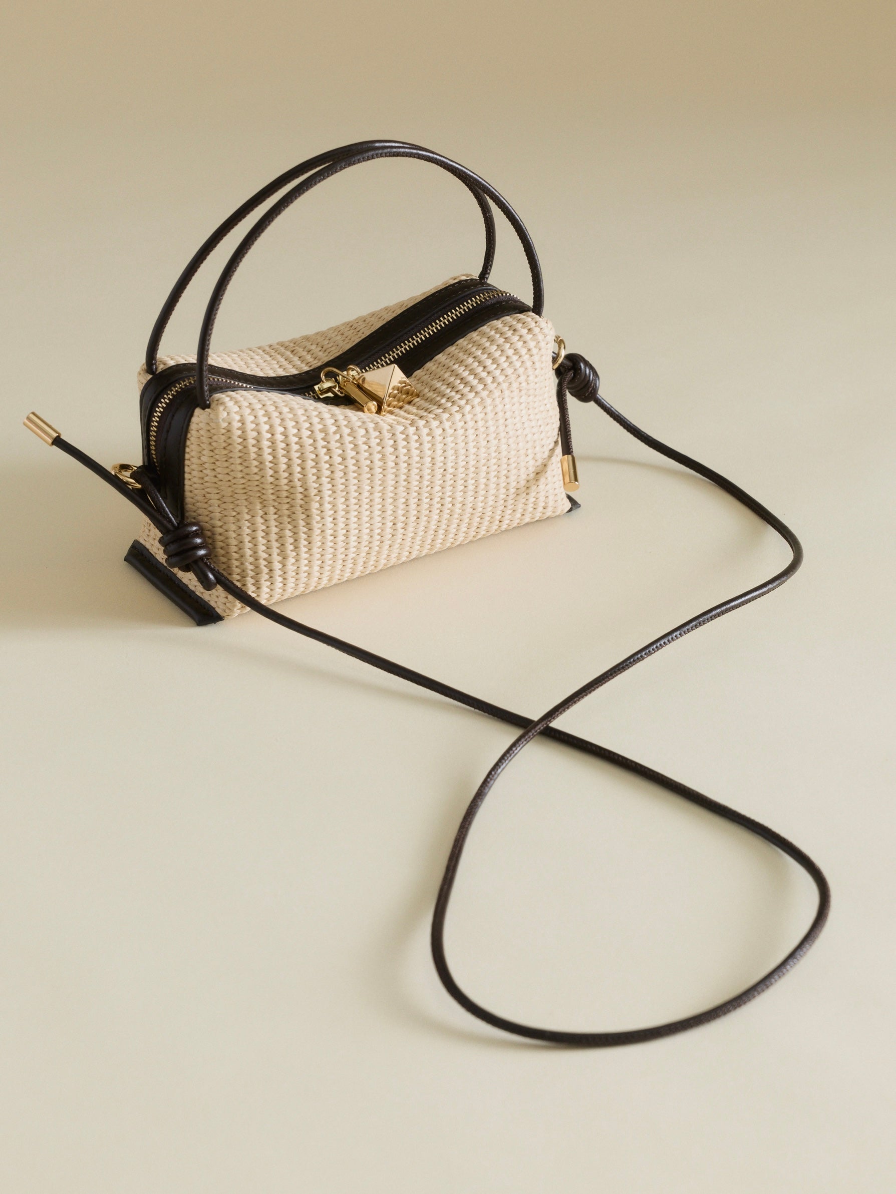 Raffia Café Mini Crossbody Handbag with a long black strap on a light background
