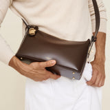 Person holding a Gold Chocolate Hobo Shoulder Handbag against a neutral background