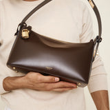 Person holding a Gold Chocolate Hobo Shoulder Handbag with visible brand name on a neutral background