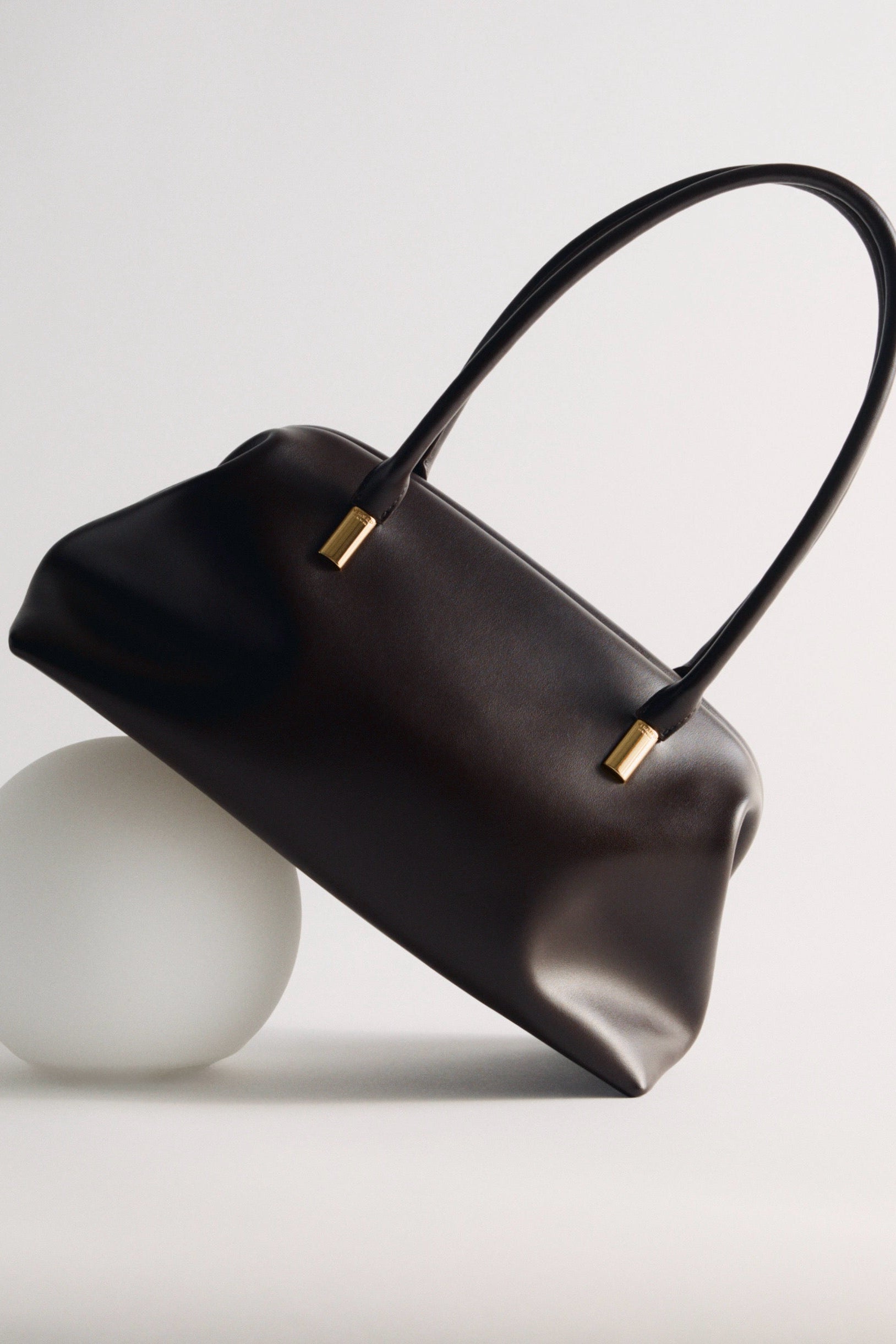 Chocolate Medium Club Shoulder Handbag with gold accents on a light gray background