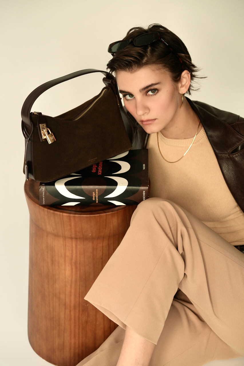 Gold Espresso Suede Hobo Shoulder Handbag on top of a book and a model