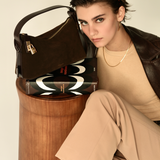 Gold Espresso Suede Hobo Shoulder Handbag on top of a book and a model