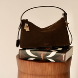Gold Espresso Suede Hobo Shoulder Handbag on top of a book