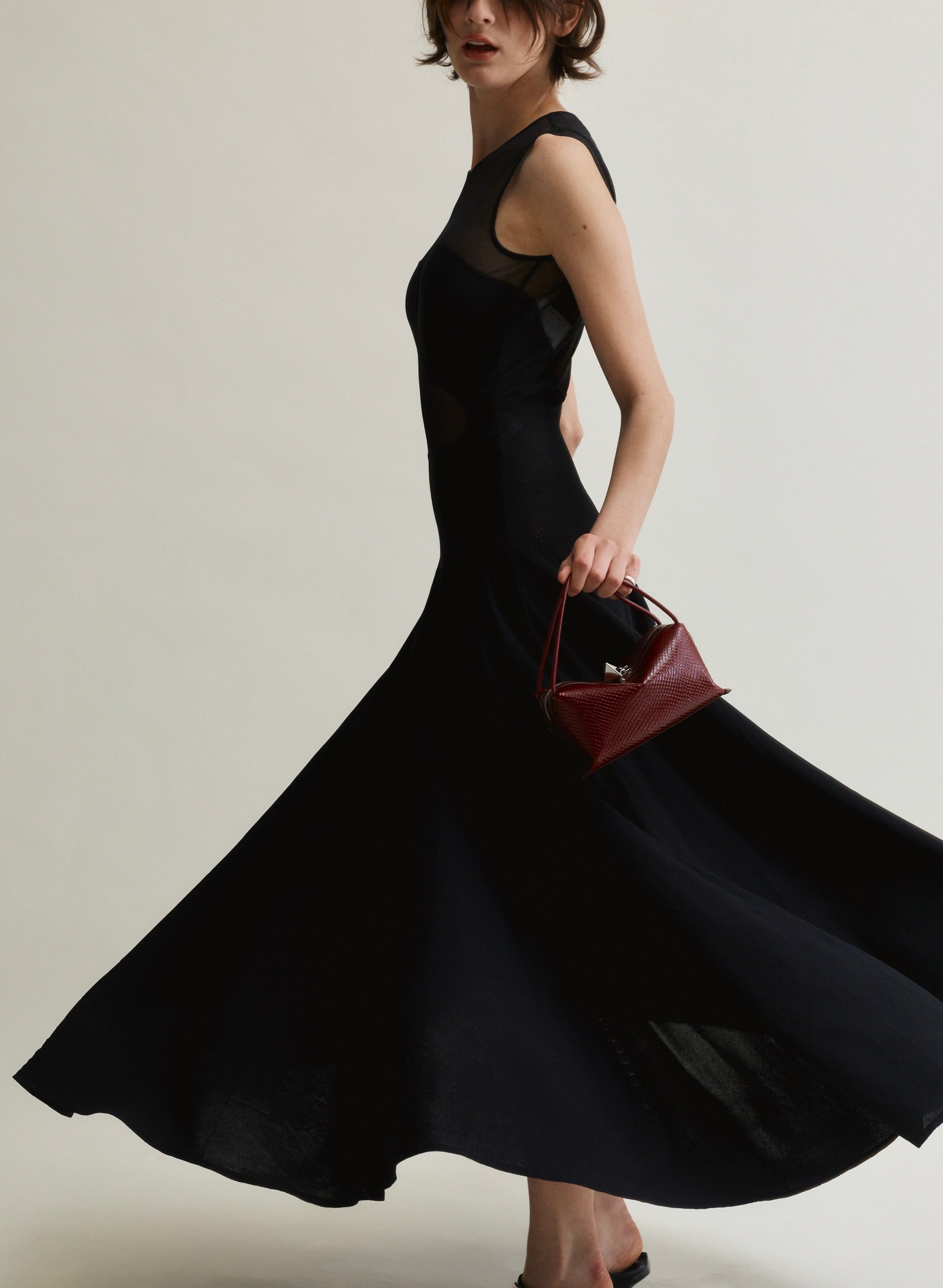 Woman in a black dress holding a r Maroon Python Café Mini Bag: Crossbody Handbag against a neutral background