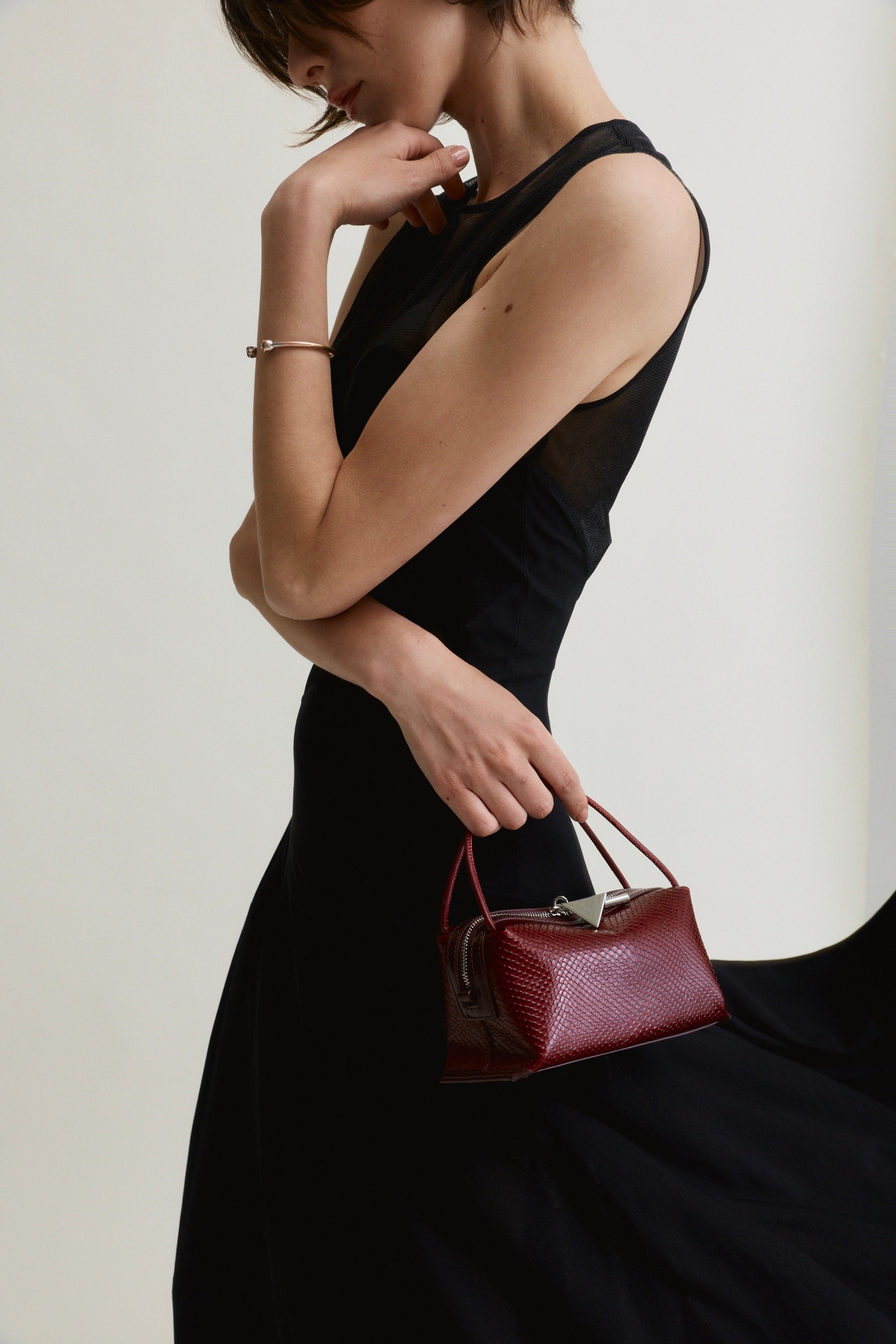 Woman holding a Maroon Python Café Mini Bag: Crossbody Handbag against a plain background