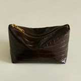 Mocha Croc Makeup Pouch with gold zipper on a beige background