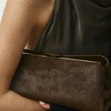 Olive Calf Hair Clutch Shoulder Handbag held by a person wearing a green dress against a neutral background