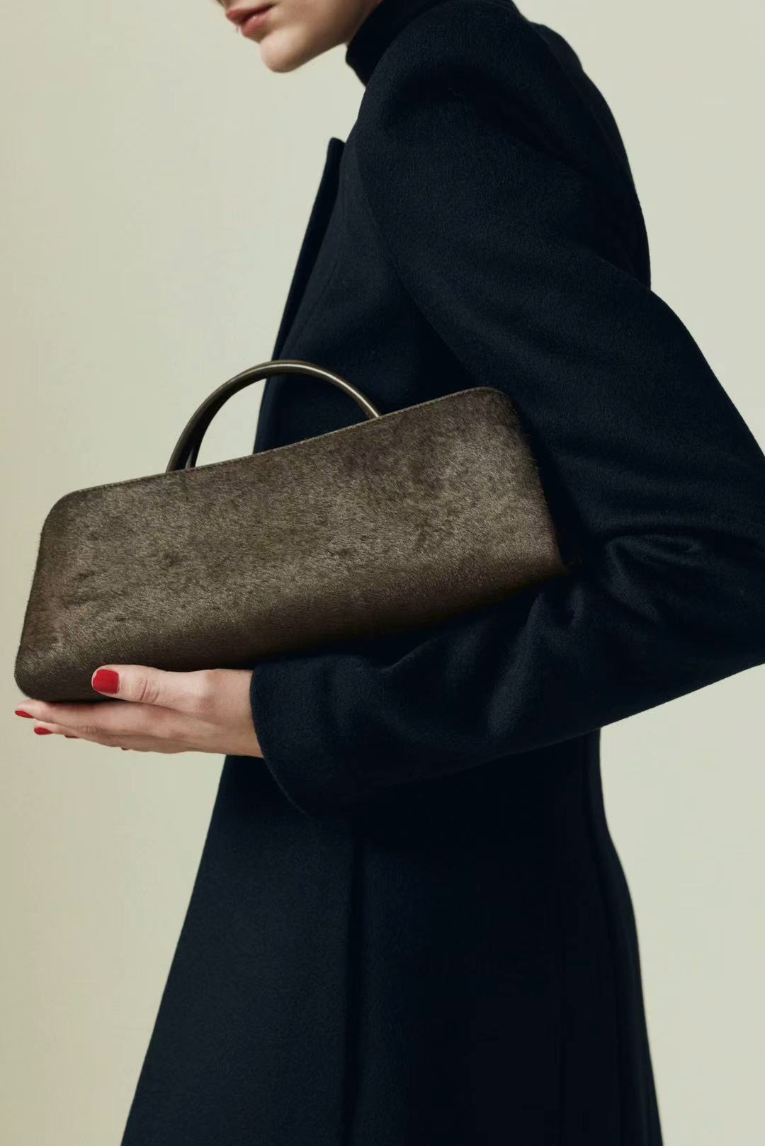 Person holding a Olive Calf Hair Clutch Shoulder Handbag against a neutral background